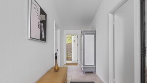 A hallway with a wooden bench, a framed picture on the wall, and a door leading to a room. - 2 bedroom gorgeous home in Gilleleje (Gilleleje)