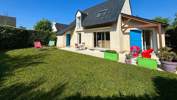 A two-story house with a sloped roof, a visible chimney, and a large sliding glass door. - Carnac: 5-room house with garden, 7 people, WiFi, pets allowed (Carnac)