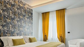 A hotel room with a large bed, a white armchair, and a patterned wallpaper. - **Lingotto Center** 5min, Luxury Apartment, 1 Bedroom, 4 guests. (Nichelino)