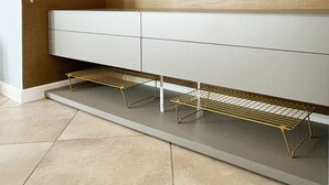 A modern bathroom with a wooden vanity, a towel rack, and a gold wire shelf. - **Lingotto Center** 5min, Luxury Apartment, 1 Bedroom, 4 guests. (Nichelino)