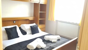 A neatly made bed with a black and white duvet, two pillows, and two rolled towels. - Apartment Weinduft (vine aromic) mountains beautyfull landscape (Appiano)