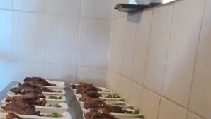 Una barra de buffet con diversos platos, incluyendo carnes y ensaladas.
