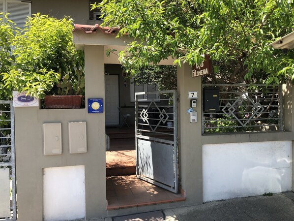 L'ingresso di un edificio con un cancello, un cartello che indica una valutazione di 9,5 stelle e il numero 7 sul muro.