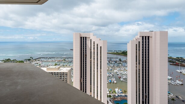 A high-rise hotel overlooking a marina with multiple boats and a clear view of the ocean. - Free Parking! 40th Floor Penthouse Studio with Stunning View (Honolulu)
