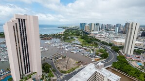 A high-rise hotel with a view of a marina and cityscape. - Free Parking! 40th Floor Penthouse Studio with Stunning View (Honolulu)