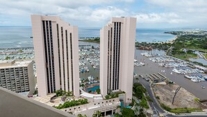 A high-rise hotel with a marina view, featuring multiple balconies and a pool area. - Free Parking! 40th Floor Penthouse Studio with Stunning View (Honolulu)