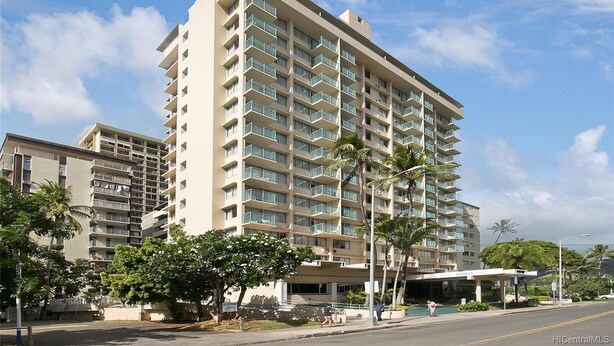 A multi-story hotel with balconies, palm trees, and a clear sky. - Studio in the Middle of Waikiki, Short walk to beach (Honolulu)