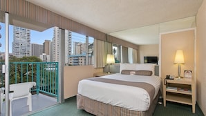 A hotel room with a large bed, a bedside table with a lamp, a chair, a small desk with a phone, and a balcony with a chair. - Studio in the Middle of Waikiki, Short walk to beach (Honolulu)