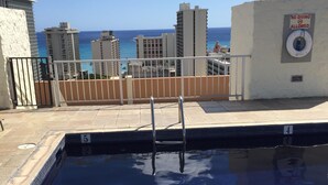 Ein Pool auf dem Dach mit Blick auf das Meer und die Gebäude.
