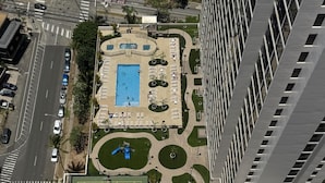 An aerial view of a building with a tennis court, a swimming pool, and a parking area. - 29th Floor Waikiki Banyan, Full Kitchen and Free Parking (Honolulu)