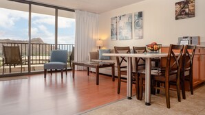 A spacious living area with a balcony, a sofa, a dining table with chairs, and artwork on the walls. - 29th Floor Waikiki Banyan, Full Kitchen and Free Parking (Honolulu)
