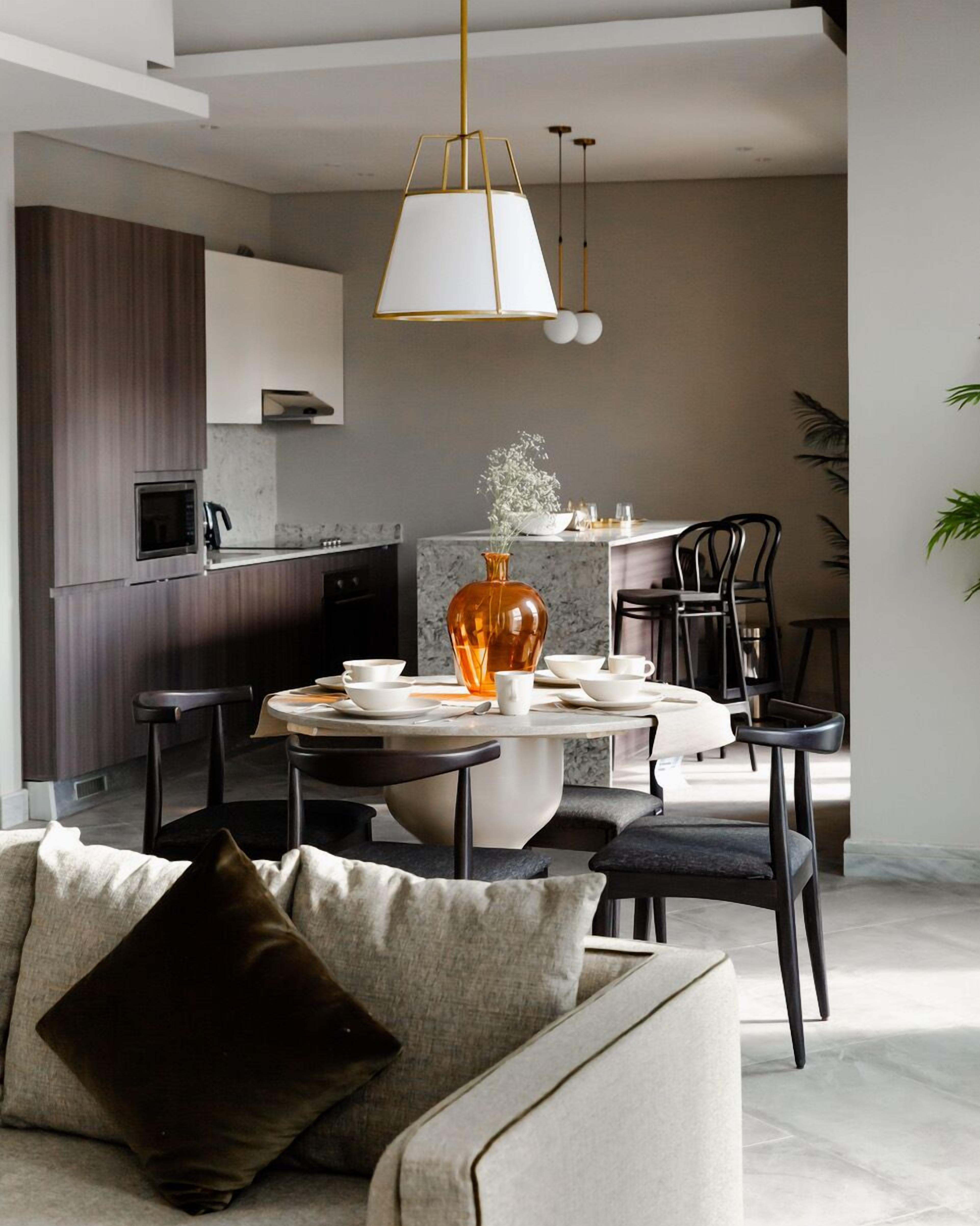 A modern kitchen with dark wood cabinets, a white countertop, and a built-in oven.