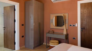 Un dormitorio con armario, tocador con espejo, mesita de noche y cama.
