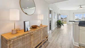 A modern kitchen with a wooden island, white cabinetry, and a large window providing natural light. - Ocean Park 114 - Hosted by Moore AI Rentals (Fernandina Beach)