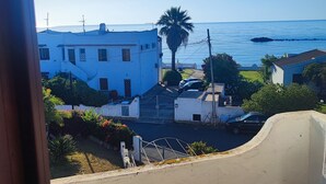 A coastal residential area with white buildings, a palm tree, and a clear view of the sea. - Villa 100 steps from the beach (CIN It092066C2000R5478) (Sardegna)