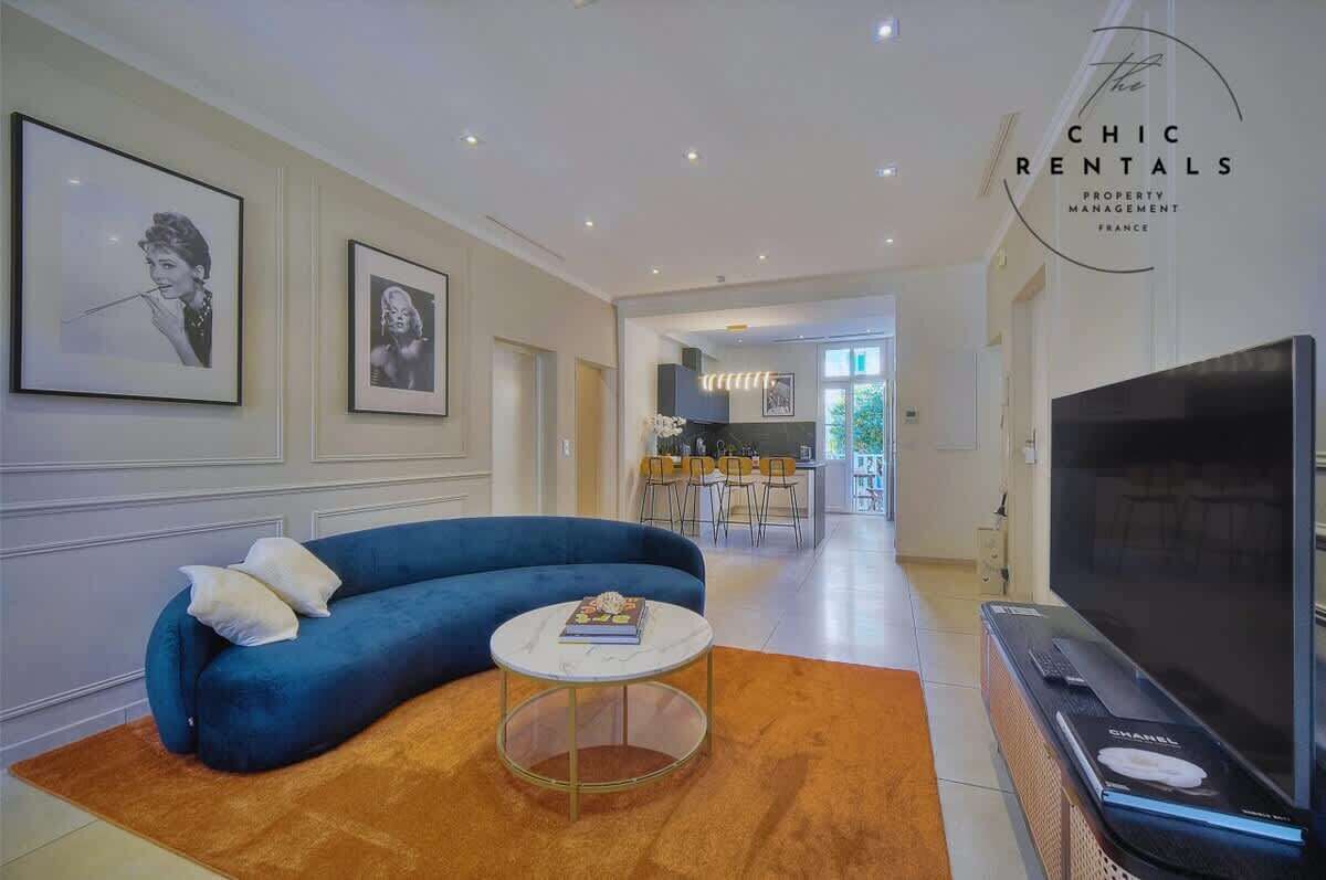 Un salon moderne avec un canapé bleu, une table basse ronde et un téléviseur à écran plat.