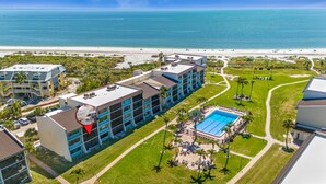 Un hotel con piscina sul tetto, vista sulla spiaggia e cortile curato.