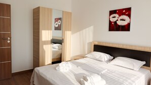 A hotel room with a bed, a wardrobe, a mirror, and a painting on the wall. - SUMMER REST (Navodari)