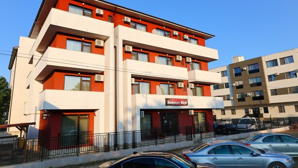 A multi-story hotel with a red and white facade, balconies, and a sign reading "Summer Rest". - SUMMER REST (Navodari)