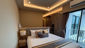 Een moderne hotelkamer met een groot bed, een telefoon op het nachtkastje, een lamp en uitzicht op het buiten balkon.