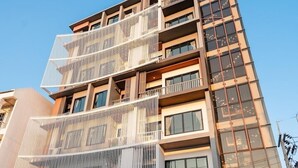 Een hotel met meerdere verdiepingen, modern van ontwerp, met balkons en grote ramen.