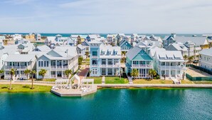 Un quartier résidentiel situé sur la côte, avec des maisons donnant sur le front de mer, dotées de balcons et d’un quai.