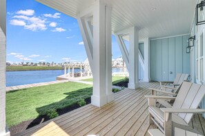 A covered outdoor area with a view of a body of water and a distant building.