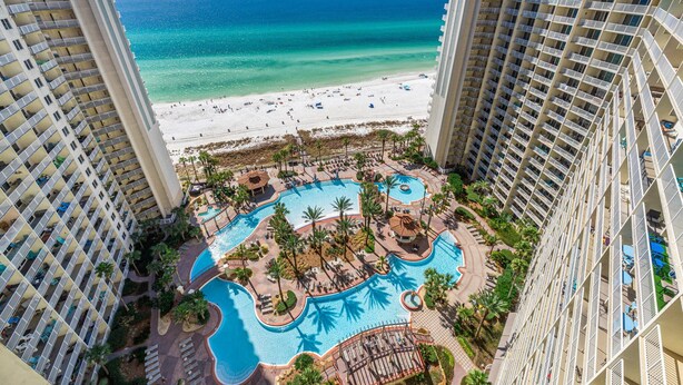 A high-rise hotel with a pool area, beach view, and multiple balconies. - Shores of Panama by Blue Swell (Panama City Beach)