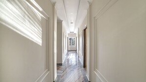 A long, narrow hallway with white walls and a marble floor. - Thanh Do 1 Hotel (Xuan Huong - Da Lat)