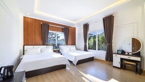 A hotel room with two beds, a desk, a chair, a mirror, and a window with curtains. - Thanh Do 1 Hotel (Xuan Huong - Da Lat)