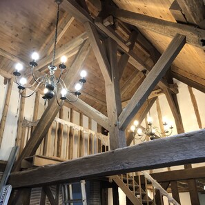 A wooden interior with exposed beams and a chandelier.