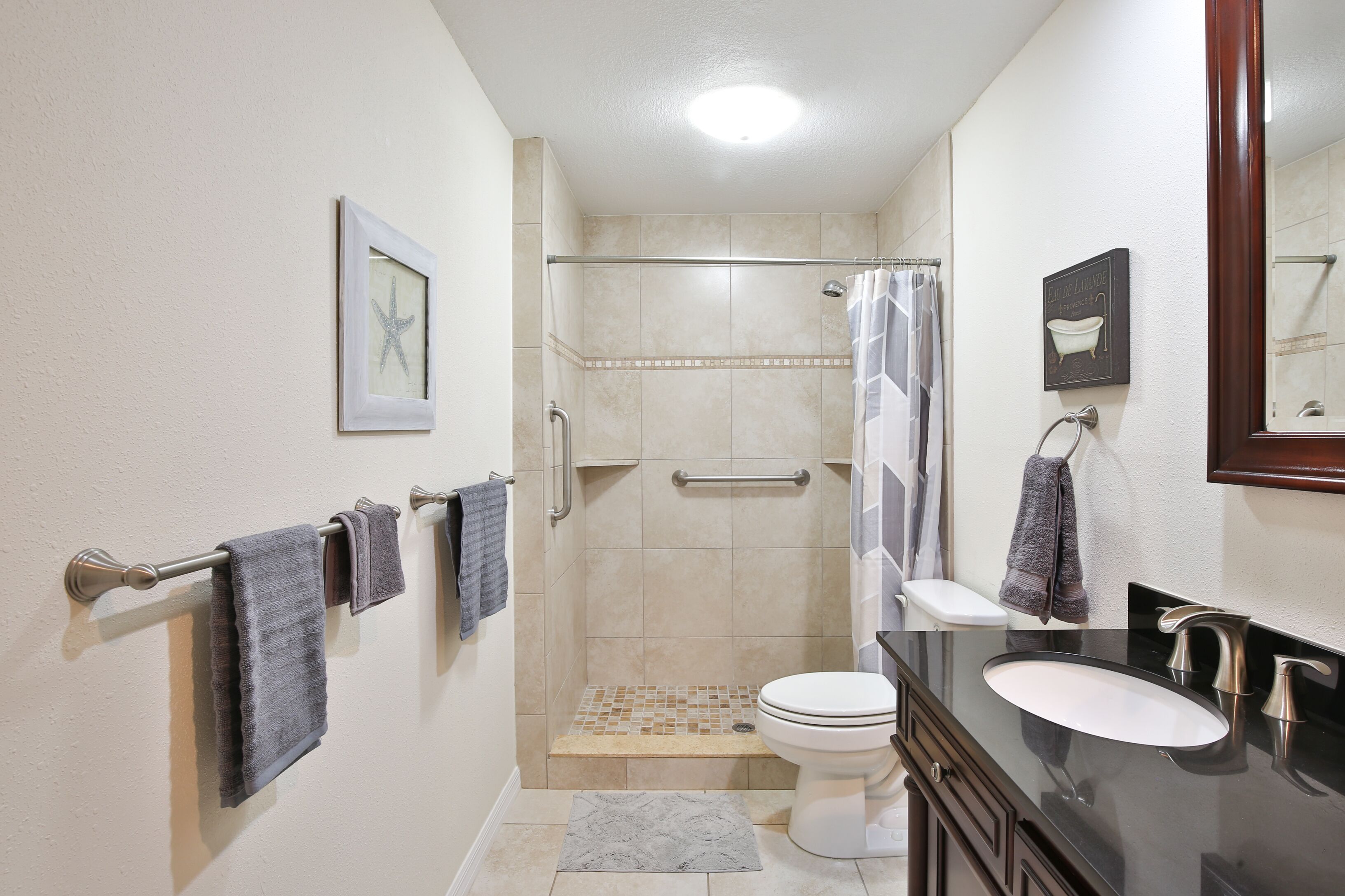 A bathroom with a shower, toilet, and sink.
