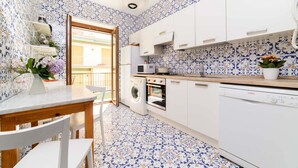 A kitchen with white cabinets, a washing machine, a microwave, and a Bosch dishwasher. - AMORE RENTALS - Appartamento Sally with Terrace and Partial Sea View (Sorrento)