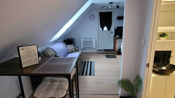 Une pièce de style loft comprenant un coin repas, un canapé, une petite table et un coin cuisine avec une cuisinière.