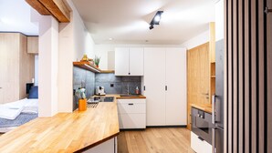 Une cuisine moderne avec des plans de travail en bois, des armoires blanches et un four encastré.