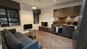 A modern living room with a sofa, a TV, and a small table.