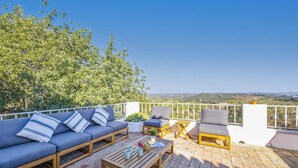 A terrace with a sofa, chairs, and a table, overlooking a scenic landscape. - Villa Quinta Marta Luisa by Villa Plus (Silves)