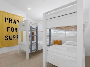Een kamer met stapelbedden, een gele banner met tekst en een houten kast.