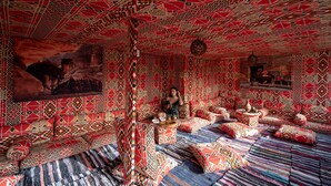 Una habitación con paredes decoradas y un cuadro grande de un paisaje desértico.