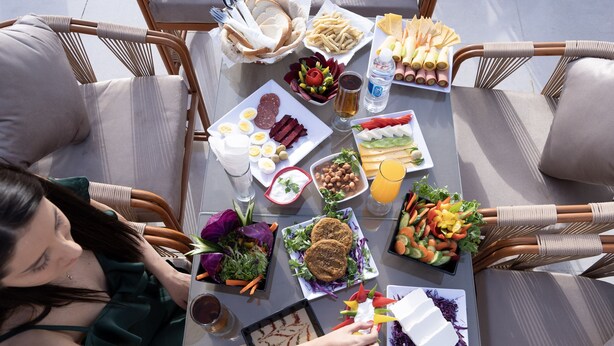 Una mesa de comedor preparada con diferentes alimentos y una persona sentada.