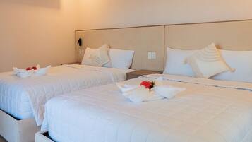 A hotel room with two beds, each with white bedding and pillows, and a wall-mounted air conditioner.