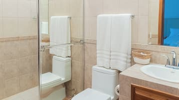 Bañera con ducha, toallas, jabón, shampoo