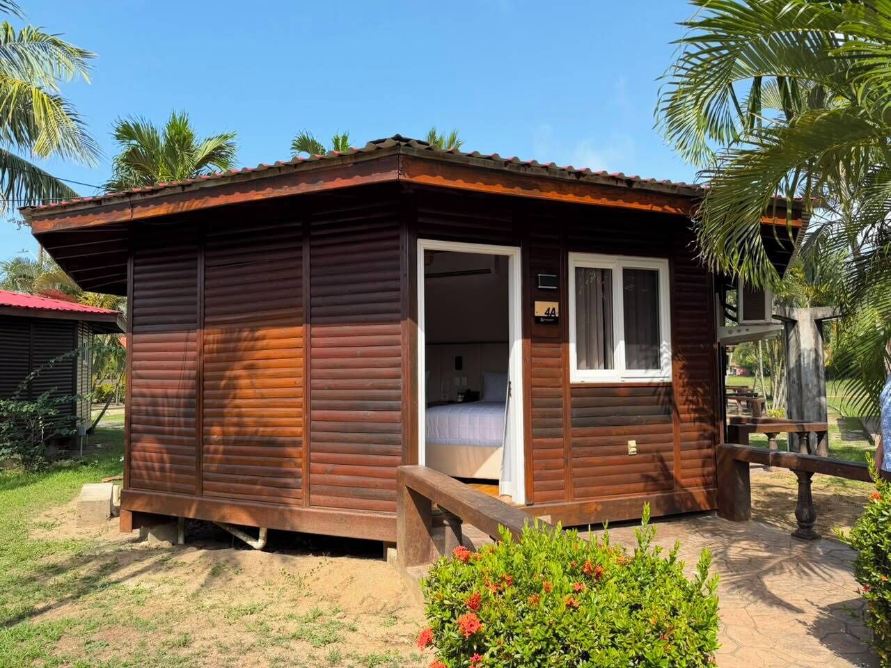 Una petita cabana de fusta amb una única habitació visible, una porta i un petit porxo.