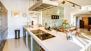A modern kitchen with a large island, stainless steel appliances, and a backsplash.