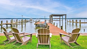 A wooden dock extending into calm water with three Adirondack chairs facing the water. - WATERFRONT!!! The River's Roost on The Patuxent River (Saint Leonard)
