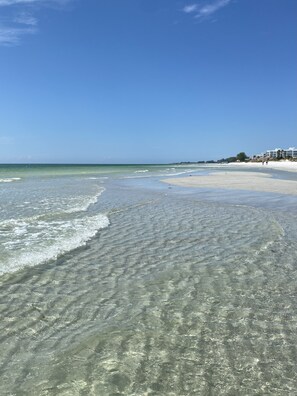 A beach with clear shallow waters and a few buildings in the background. - Beach lovers paradise!  (Longboat Key)