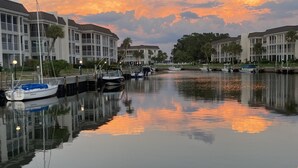 A marina with boats docked, calm water reflecting the sky, and modern buildings with large windows. - Beach lovers paradise!  (Longboat Key)