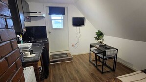A compact living space with a kitchenette, a dining area, and a seating area.