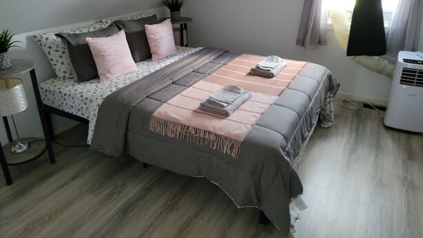 A bedroom with a bed, bedside tables, a lamp, and a window with curtains.