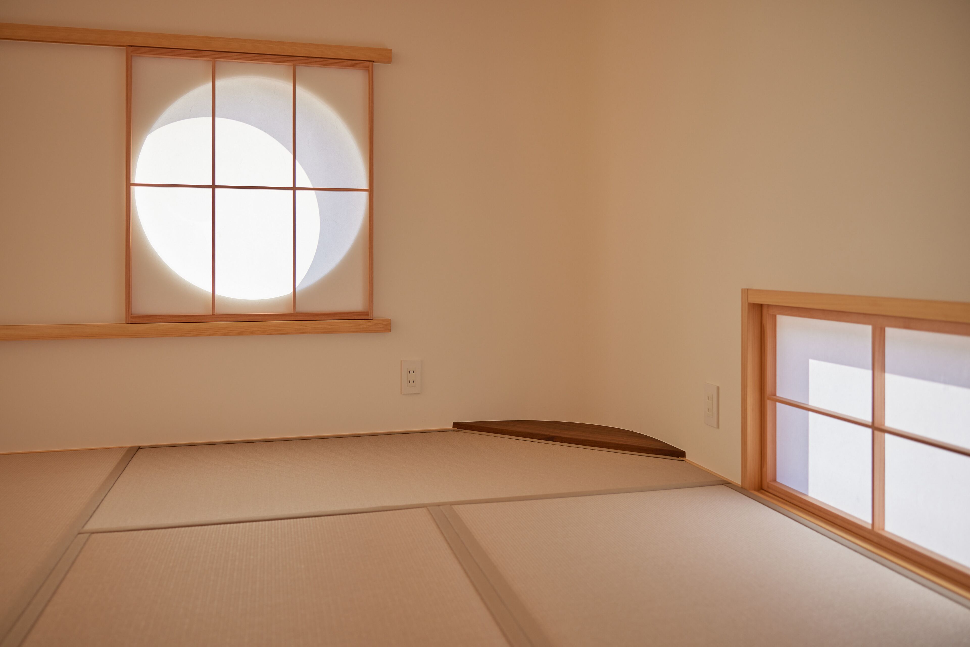 A room with tatami flooring, a shoji screen window, and a wooden door.